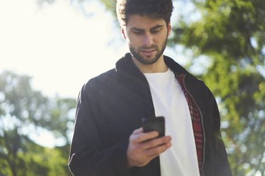 Yakışıklı beyaz hipster açık havada smartphone becerikli alet ile mesajlaşma