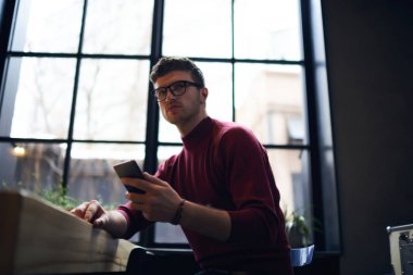 Telefonun kapalı duruyordu üzerinden sosyal ağlarda arkadaşlarınızla sohbet Vconcentrated genç erkek öğrenci