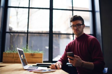 Kapalı cep üzerinde uygulama kullanarak hipster adam