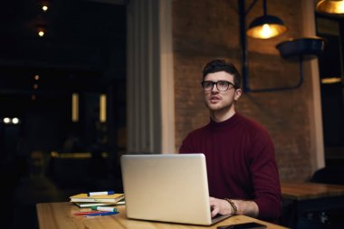 Genç öğrenci ödev görev alan coworking içinde vakit hazırlanıyor