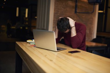 Satressed ve endişeli işadamı kapalı kafede dizüstü bilgisayar ve serbest zaman sırasında Internet ücretsiz kablosuz bağlantı kullanarak