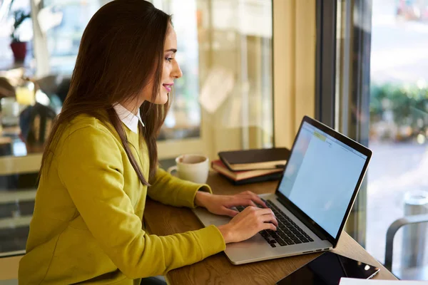 Freelancer feminino usando computador portátil e conexão sem fio gratuita à internet — Fotografia de Stock