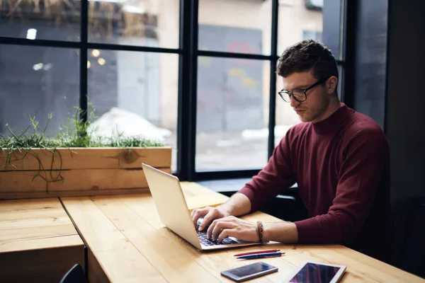 Freelancer masculino viendo webinar de entrenamiento usando conexión inalámbrica gratuita a wifi en el espacio de coworking — Foto de Stock