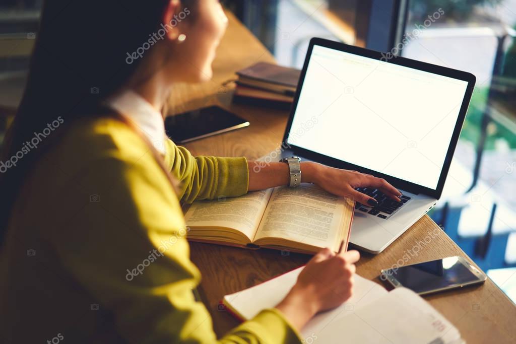 Woman freelancer surfing internet for report doing project in coworking space with wifi access