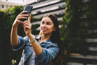 Selfie fotoğrafları modern telefon aygıtı için sosyal ağlar yayın yapma olumlu çekici genç kadın. Hücresel mobil uygulama dijital üzerine resimleri alarak olumlu güzel kadın