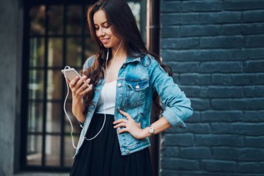 Şık olumlu blogger web sitesinde radyo online modern kulaklık müzik dinleme telefona bağlı. Neşeli hippi kız smartphone cep telefonu ile en sevdiğiniz şarkıları eşliğinde arkadaşlarınızla sohbet