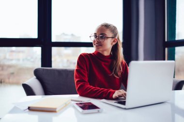 Modern iç ofis modern netbook kullanarak proje üzerinde çalışmaya zevk yaratıcı kadın web tasarımcısı.