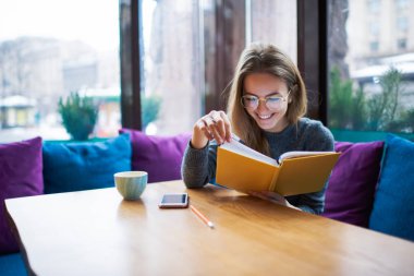 Optik Gözlük şık kafe kitapta zevk içinde zeki öğrenci.