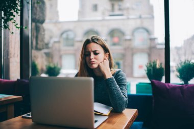 Yorgun öğrenci dijital dizüstü cihaz oturan sınavlarına hazırlanıyor.