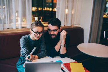 Havalı gözlükler komik webinar Web sayfasında dizüstü bilgisayar içinde izlerken neşeli iyi görünümlü çalışanların.