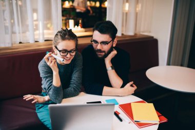 Havalı gözlükler komik webinar Web sayfasında dizüstü bilgisayar içinde izlerken neşeli iyi görünümlü çalışanların.