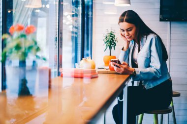 Çekici genç bayan smartphone online video izlerken.