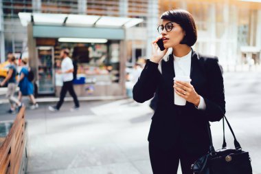 Formal giyim telefon konuşmayı açık havada kahve paket, cep telefonunuzda uzakta iş arayan konuşmak emin işkadını tutan mola sırasında ciddi kadın sahibi giymiş