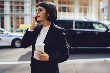 Gitmek için cazip iş kadını zarif aşınmaya taksi yolu ile kullanma smartphone kahve ile arama portresi.