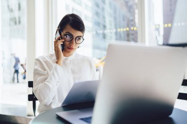 Banka hesabı laptop Servisi operatör, netbook hakkında bilgi tarama yaparken mobil konuşmayı ciddi kadın patron ile telefonda konuşurken kontrol emin iş kadını