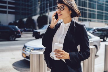 Başarılı kadın yönetici şehir caddede yürüyüş ve kopya alanı için marka nam ile gitmek için telefon konuşmayı kahve holding çalışmaları hakkında mobil, müreffeh işkadını konuşurken zarif aşınmaya