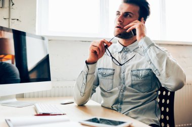 Dalgın işadamı meslektaşı ile cep telefonu konuşurken işbirliği teklif hakkında düşünme.