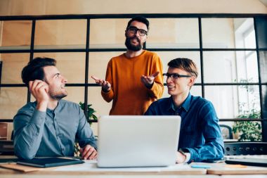 Birlikte laptop kullanırken sorun çözme Koç ile danışmanlık yapma genç erkek programcılar mürettebatı