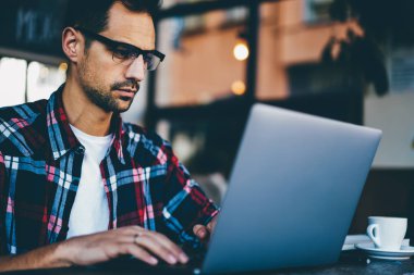 Dizüstü bilgisayar kullanan yüksek hızlı internet bağlantısı para online transfer şık optik gözlük işadamı kırpılmış görüntü. Genç grafik tasarımcı netbook uzaktan çalışma adam