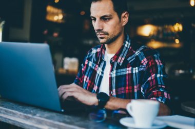 Yakışıklı genç kırpılmış görüntü programcı Uzaktan Kablosuz 4 g için bağlı modern dijital dizüstü bilgisayarda çalışan adam Internet. Öğrenci kafede oturan netbook üzerinde uygulama yükleme