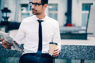 Kırpılmış görüntü içinde serin gözlük almak uzakta kahve dışında serbest zaman zevk emin iyi görünümlü iş adamı. Akıllı erkek avukat İstasyonu'nda otururken taze gazete okuma