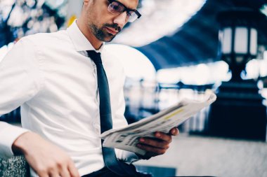 Yetenekli genç iş adamı şık gözlükler dikkatle popüler ekonomi gazete okuyan Resim kırpılmış. Açık havada medya bilgileri kontrol yaratıcı erkek girişimci görüntüsünü kapatmak