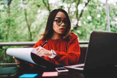 Gözlük zeki kız öğrenci teknolojileri, kafe teras dizüstü bilgisayar ile uzaktan çalışma bütçe yetenekli işkadını sayım gelirleri kullanarak rapor yapma ev ödevi yazmaya konsantre