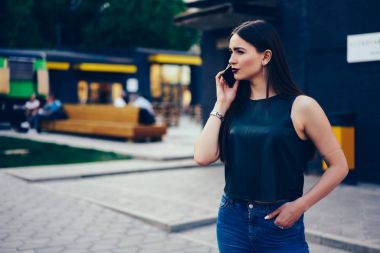 Güzel esmer açık havada yürüyüş sırasında smartphone telefon konuşma ile sokulgan yolu ile uygulama sahip durulması. Düşünceli genç kadın cep telefonunuzun Sokağı'nda gezinme sırasında söz