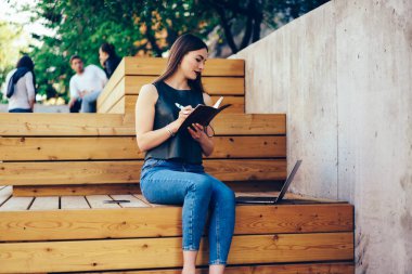 Eğitim webinar Web sitesinde dizüstü bilgisayar içinde izlerken ve not defteri için genel kavramları notating genç güzel kadın. Modern aygıt üzerindeki uygulama kullanma çalışma programı planlama güzel hippi kız