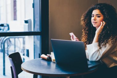 Portre çekici freelancer bildirim smartphone cep telefonu ile internet'e bağlı denetimi şık giyim giymiş. Şirin hippi kız üstünde laptop para transfer sırasında arkadaşlarınızla sohbet