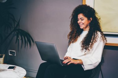 Genç duygusal freelancer Web sitesinde becerikli alet içinde komik film izlerken internet'e bağlı şık giyim giymiş. Sevimli gülümseyen kadın kişi kafede dizüstü bilgisayarda uzaktan çalışma sırasında eğlenmek