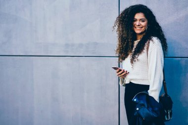 Muhteşem duygusal kadın kişinin portre promosyon arka plan ile duvara reklam içerik için ayakta ve sosyal ağ içinde takipçileri ile haber paylaşımı trendy giyim giyinmiş