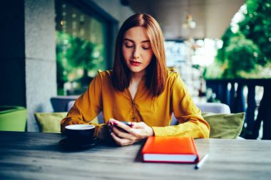 Genç çekici hippi kız sosyal ağ smartphone için 4 g bağlı üzerinden takipçileri ile şık kıyafet sohbet giyinmiş. Kafede ücretsiz vaktinizi Burun piercing ile şirin Kızıl saçlı kadın