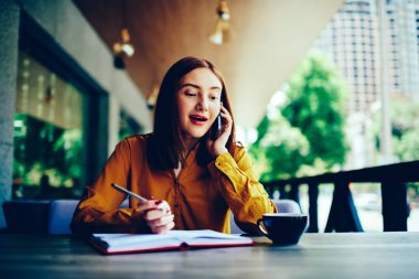 Dalgın tatlı yetenekli öğrenci trendy kıyafeti iyi atmosfer telefonda uygulama kullanarak arkadaşlarınızla iletişim giymiş. Açık havada hareket eden konuşmayı çekici komik Kızıl saçlı kadın