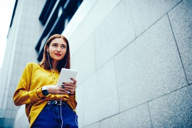 Dalgın kadın boş vaktinizi şık kılığına girmiş ve kulaklık ve dijital tablet yayın dinlerken promosyon arka plan yakın yaz yürüyüş sırasında Internet bağlantısı