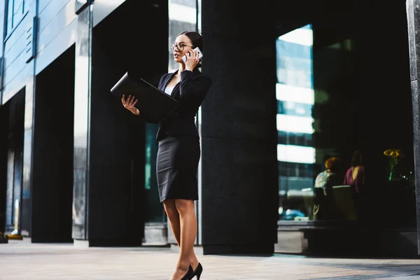 黒のビジネス プランナーを手で押し 屋外で立って携帯電話で同僚と話して正装で豊かなエグゼクティブ マネージャー スマート フォンでパートナーを呼び出す若い女性起業家 — ストック写真