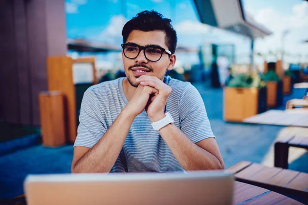 Gözlük bekliyor dalgın erkek öğrenci netbook üzerinde güncelleme kurulum bitirme.