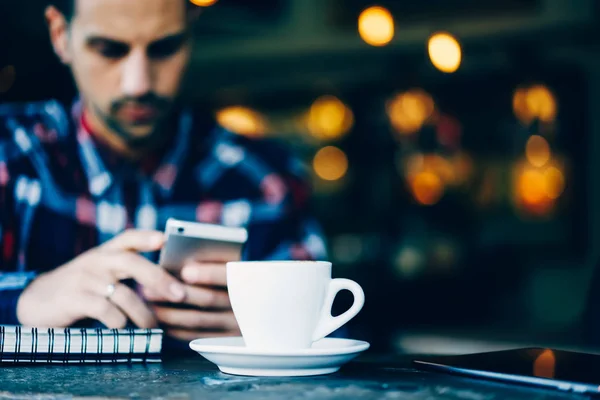 Joven Hipster Chico Charlando Línea Dispositivo Teléfono Inteligente Cerca Taza —  Fotos de Stock