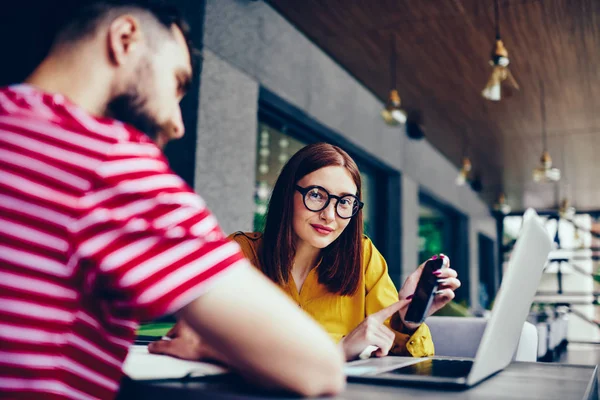 Yarım uzunlukta laptop arıyorum sakallı erkek partner ise smartphone kullanarak sevimli Kızıl saçlı kadın portresi. Genç yaratıcı iş arkadaşlarınızla birlikte modern cihazlar kullanarak rahat kıyafet çalışma içinde giyinmiş