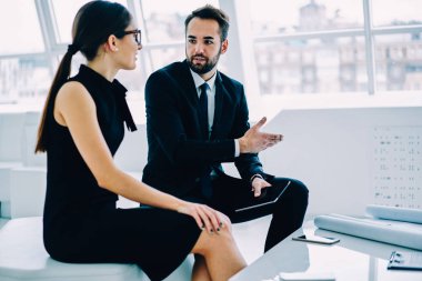 Erkek ve dişi mimarlar, ofiste görüş Paylaşımı çalışma planları hakkında konuşmak birlikte işbirliği yaparken yaratıcı çözüm yapma resmen giyinik meslektaşları başlangıç hazırlama proje