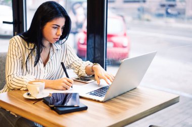 Dizüstü bilgisayarda mesafe çalışması sırasında internet sörf yaparken araştırmalar yapma genç güzel profesyonel kadın serbest meslek. Eğitim webinar Web sayfasında becerikli alet içinde izlerken dalgın metin yazarı