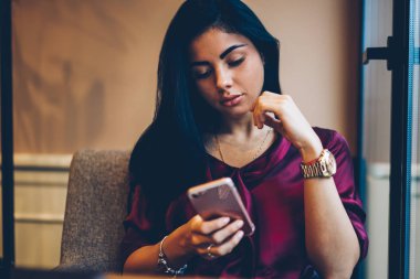 Genç çekici kadın blogger rekreasyon kapalı kişisel web sitesi aracılığıyla telefon ve 4 g takipçileri ile sohbet ederken zevk internet. Kapalı modern teknoloji kullanan büyüleyici hippi kız