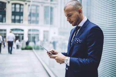Ciddi iş adamı kontrol e-posta kutusu şehir sokaklarında vakit sırasında uygulamaya üstünde değmek yolu ile tablet ayakta yakınındaki tanıtım yoluyla son finansal haber okuma kendine güvenen erkek tüccar vardır