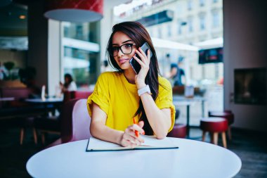 Çekici genç kadın ile sokulgan yolu ile telefon başvurusunda şık kıyafet irtibata giyinmiş. Güzel esmer kadın kapalı otururken internete bağlı cep telefonunda söz