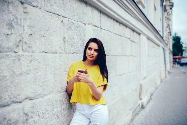沉思美丽的女人穿着时髦的衣服看着走 而网上购物的智能手机连接到4G 互联网 可爱的年轻时髦女孩在城市环境中度过空闲时间 — 图库照片