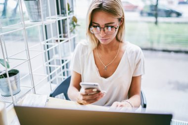 Üstten Görünüm okuma optik şık gözlük içinde sarışın genç kadın alan coworking içinde masada oturan arkadaş sms mesaj aldım. N sosyal ağlar sohbet gözlük kadın girişimci