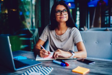 Rüya gibi genç öğrenci ders proje günlüğüne, çekici hippi kız Eyewear kafede vakit süre hedeflerine ulaşma için Not Defteri'nde listelemek yapım notları yapma fikri üzerinde durulması