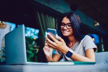 Kız öğrenci kafe iç, başarılı genç girişimci ödev yapmakla erkek Sms almak mutlu neşeli heyecanlandırmak için meslektaşım telefon geri göndermeye ilk iş teklifi ile