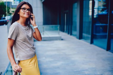 Süre servis için modern inşa edilmiş yapı, gözlük iletişim meslektaşım mobil iş tatilinde açık havada genç kadın yakınındaki toplantı iş telefonla iletişim çekici esmer öğrenci