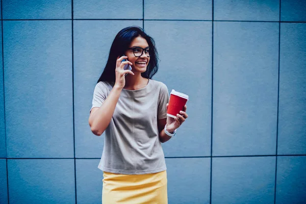 陽気な女性の同僚と新しいプロジェクトの詳細について電話プロモーション背景の上に立って幸せな実業家の自由な時間を楽しむコーヒー休憩中に携帯で話している室長 — ストック写真